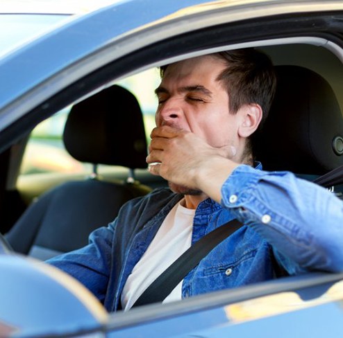 Man yawns while driving