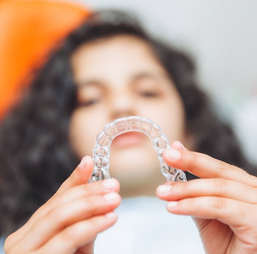Patient in Port Charlotte holding clear aligners 
