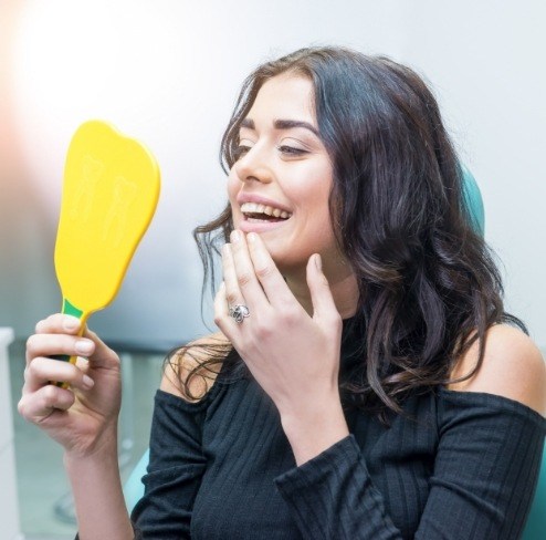 Woman looking at smile after makeover