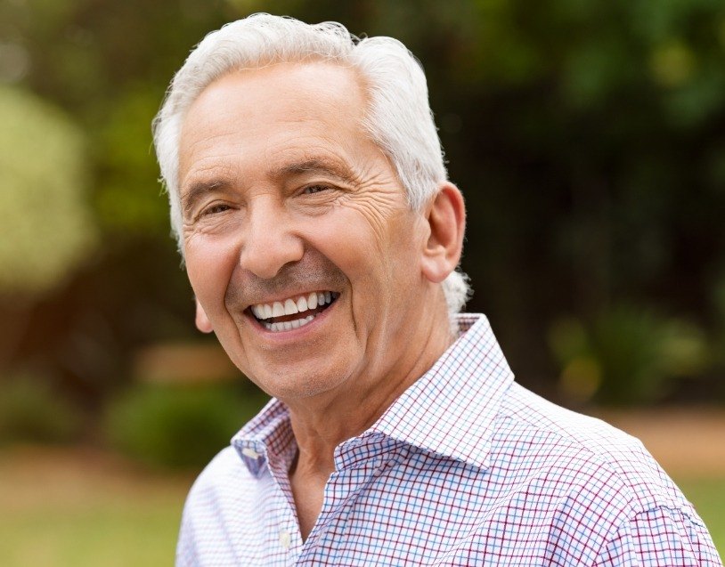Man with healthy smile after dental bridge restoration