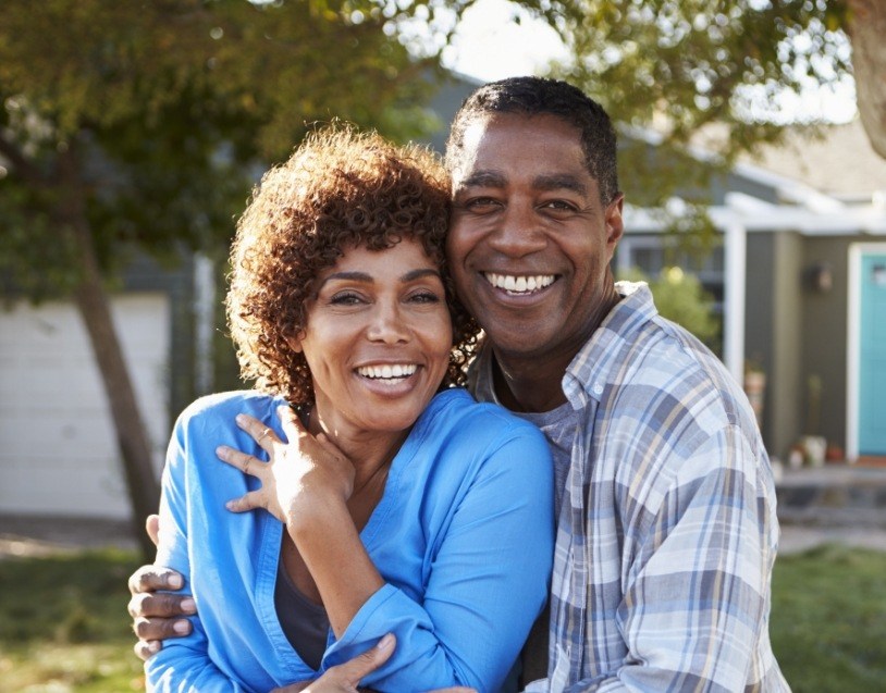 Man and woman with healthy smiles after dental crown restoration