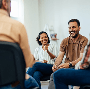 a man with dentures talking and laughing with others