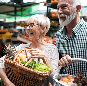 a mature couple with dentures grocery shopping