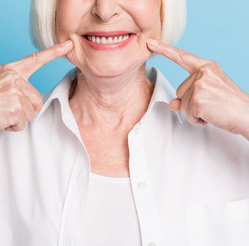 woman pointing at her dentures in Port Charlotte