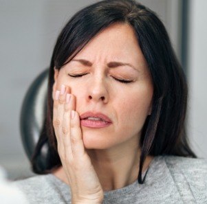 Woman with jaw pain holding her cheek