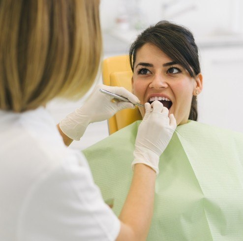 Woman receiving dental checkup to prevent dental emergencies