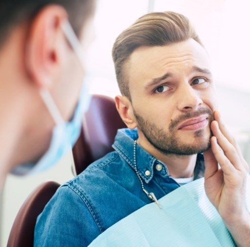 Patient holding his cheek before emergency dentistry