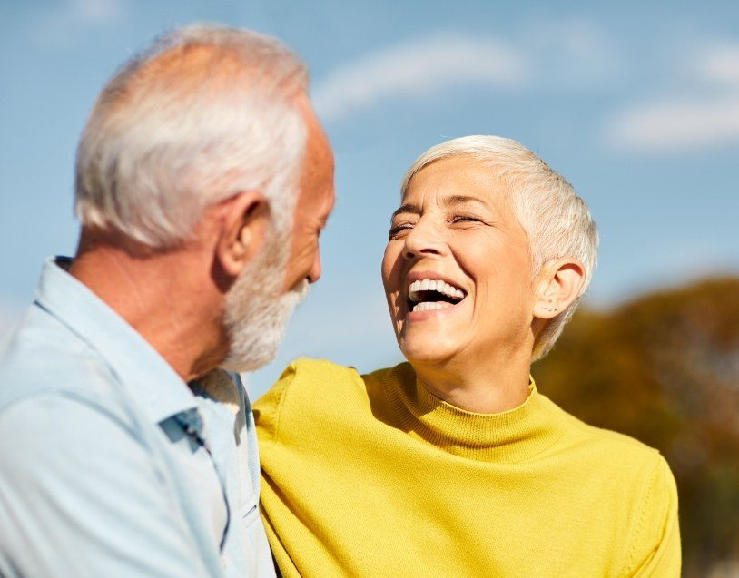 Man and woman smiling after tooth extractions