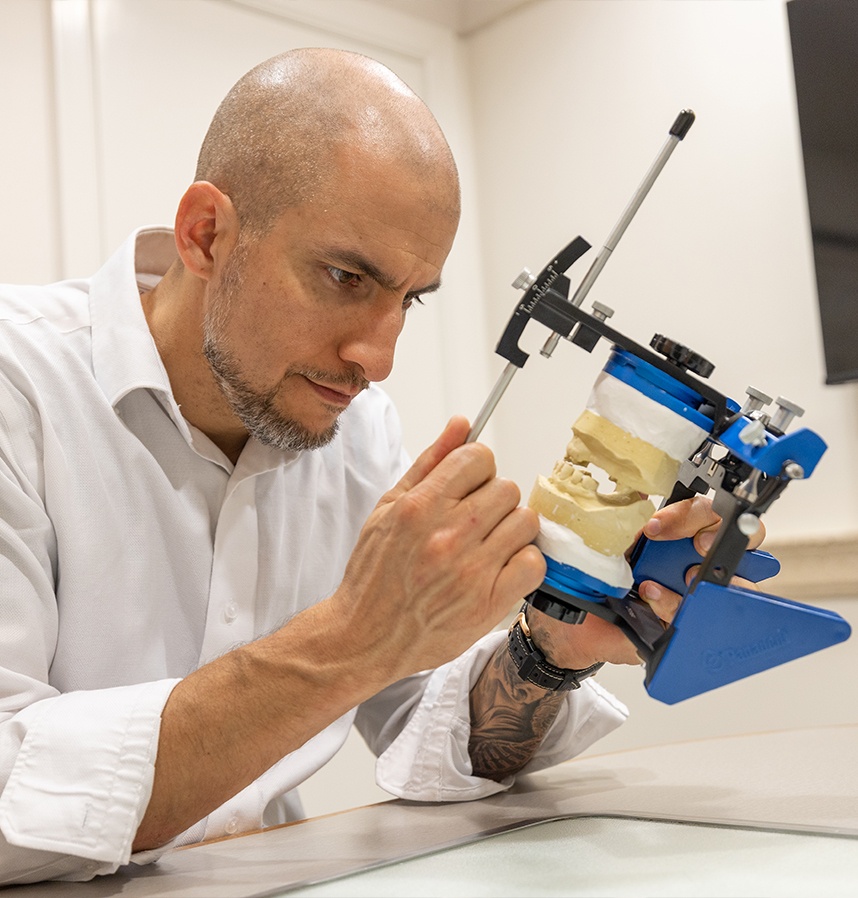 Port Charlotte dentist Doctor Bryan Villescas looking closely at a model of the teeth and jaws