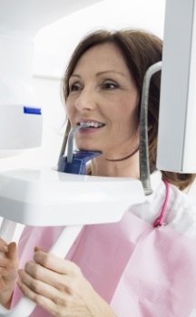 Woman receiving 3 D C T cone beam x ray scans in dental office