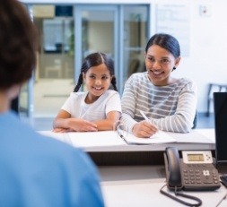 Mother and daughter checking in at dental office front desk