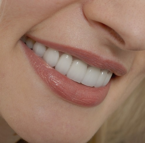 a patient pointing to his whitening smile