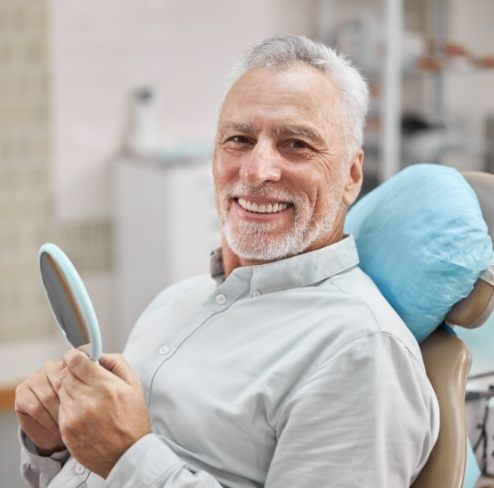 Man sharing healthy smile after replacing missing teeth with dental implants