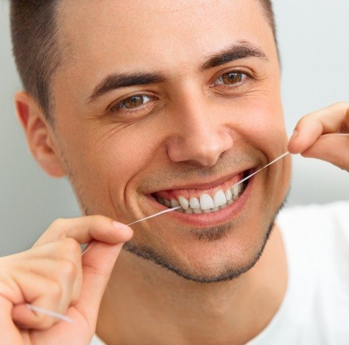 Man flossing teeth to prevent gum disease