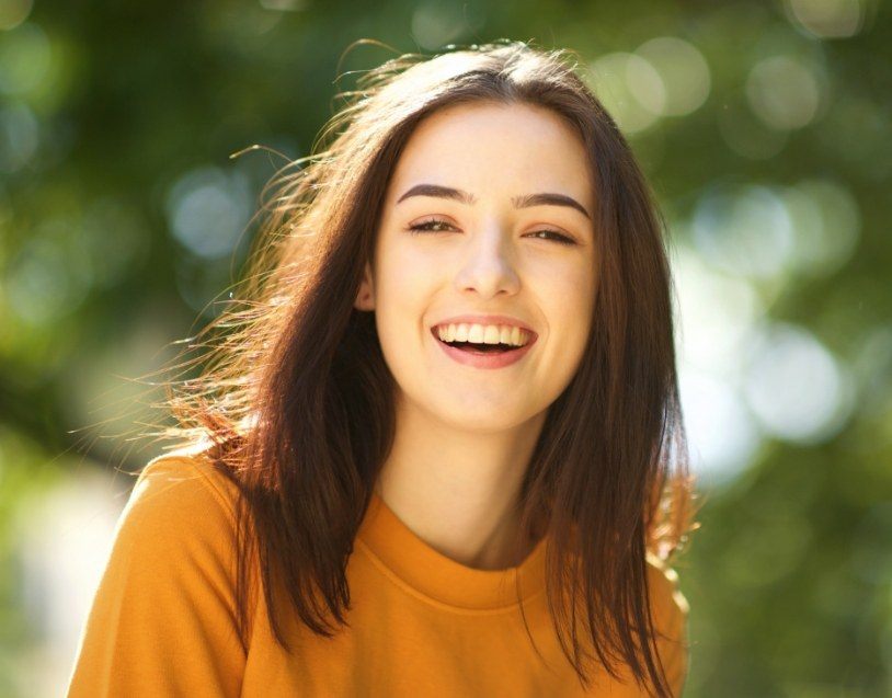 Woman with healthy smile thanks to protective dental sealants