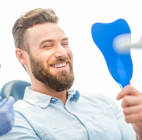 Man looking at smile after dental sealants
