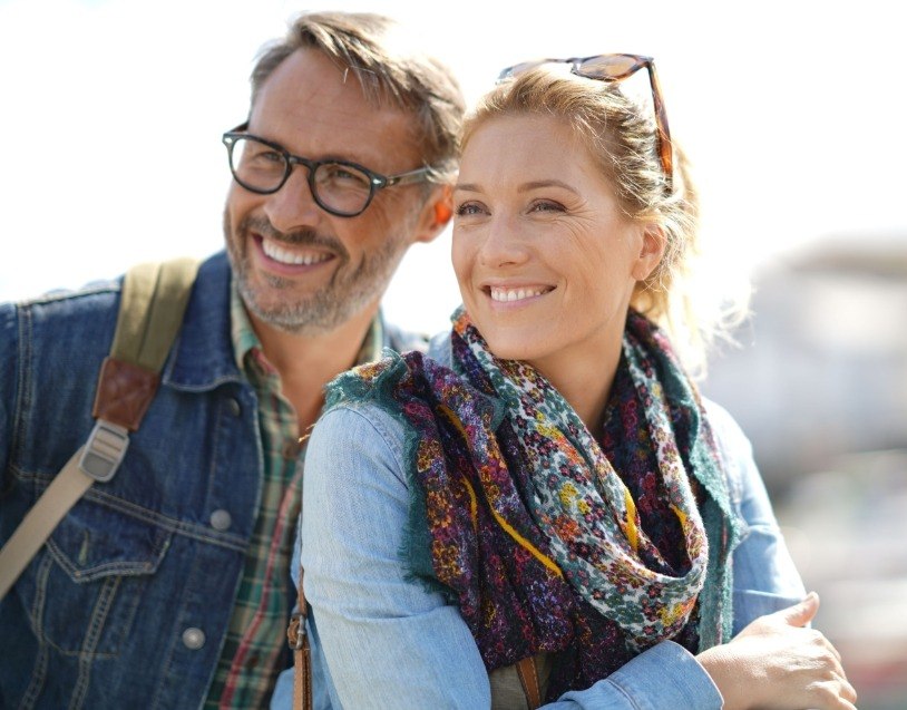 Man and woman sharing healthy smiles after advanced dental services