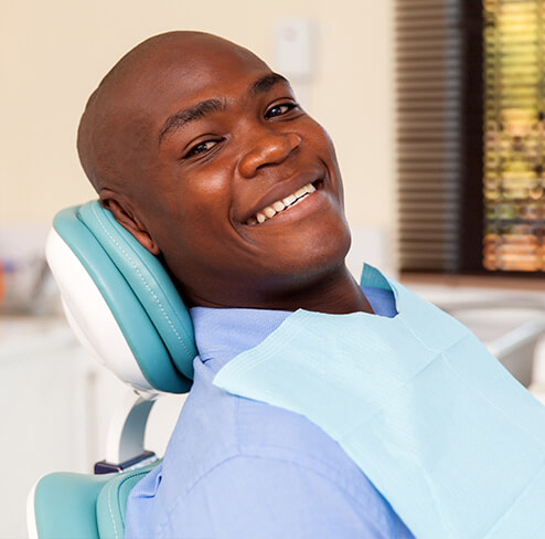 Man smiling after receiving tooth-colored fillings