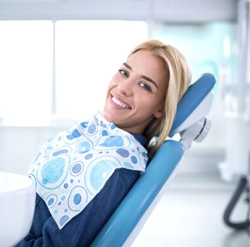 Woman with veneers in Port Charlotte smiling in dentist’s chair