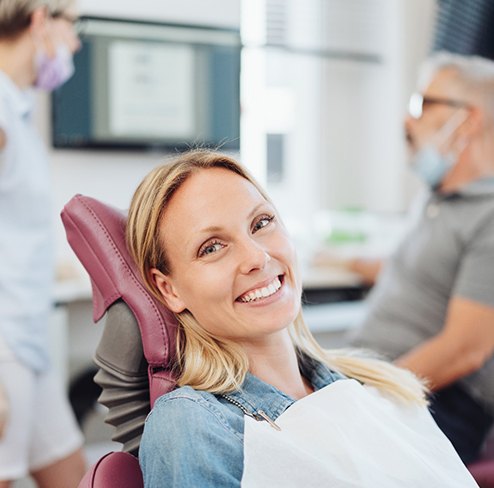 a patient smiling while visiting her dentist