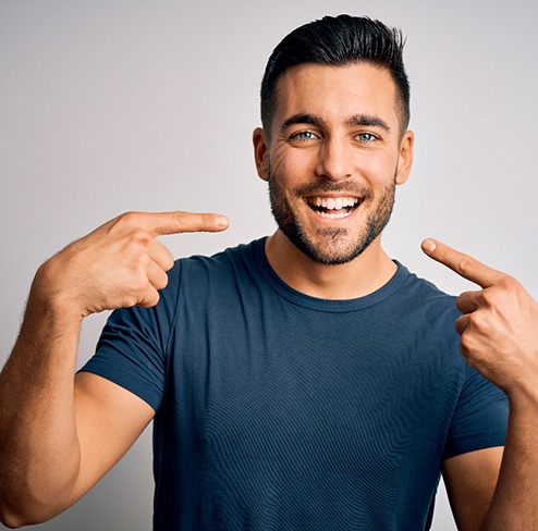 a patient pointing to his whitening smile