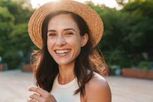 Woman wearing a hat smiling outside