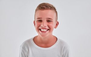 Boy smiling with white shirt and white background