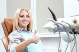 Woman in dental chair giving thumb up