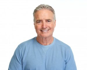 Older man smiling while wearing blue shirt