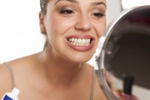 Woman looking at her smile in the mirror