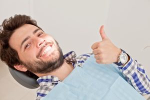 Man giving thumbs up while in dental chair