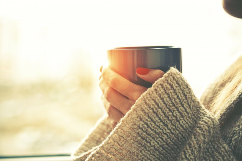 A woman about to enjoy a cup of tea after her teeth whitening treatment