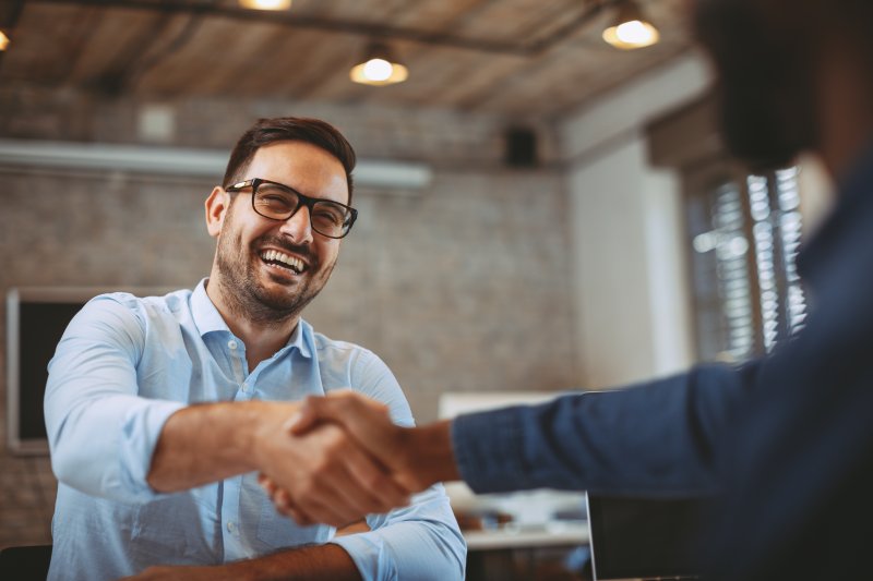 Man shaking hands with a client after cosmetic dentistry