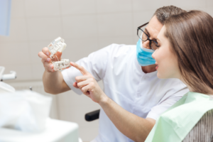a dentist demonstrating how implant dentures work