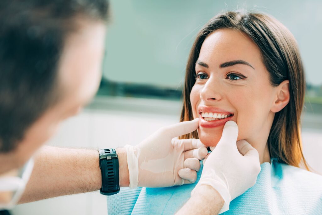 White-gloved hands of dentist touching woman's jaw